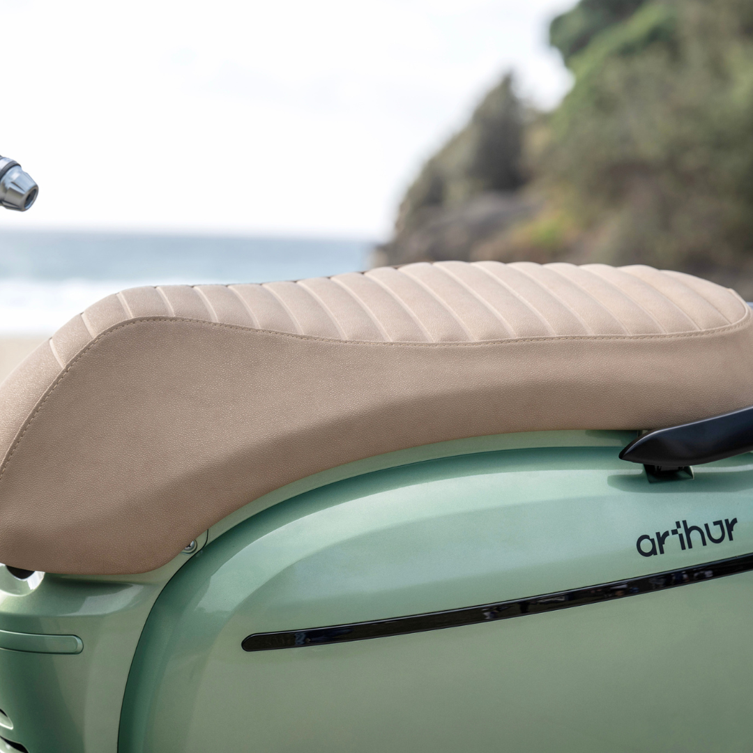 Sand Italian vegan-leather saddle on a Cuban Green FONZ Arthur scooter by the coast
