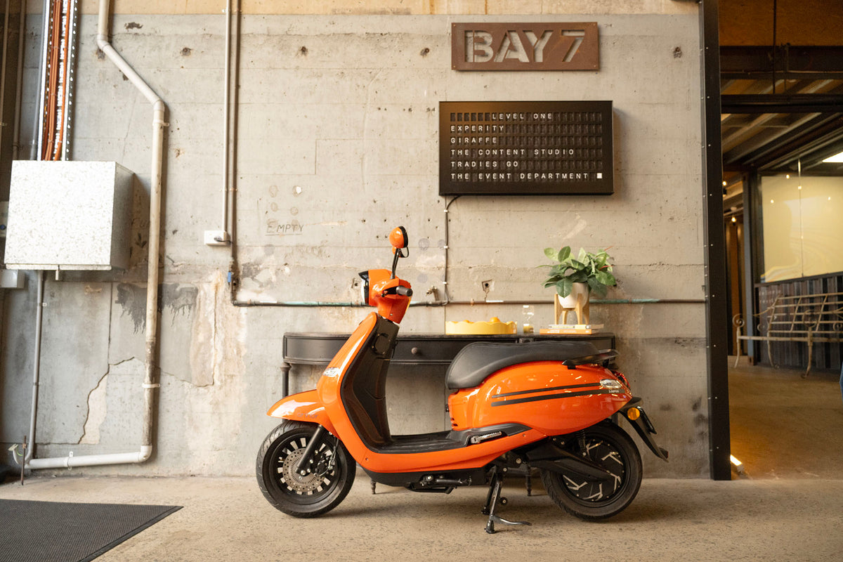 FONZ Arthur Z Series electric scooter in Forza Aranciata orange, parked in a warehouse space